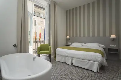 a hotel room with a tub and a bed and a bath tub at Hotel San Lorenzo Boutique Plaza in Valencia