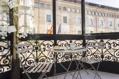 a table and two chairs on a balcony with a window at Hotel San Lorenzo Boutique Plaza in Valencia
