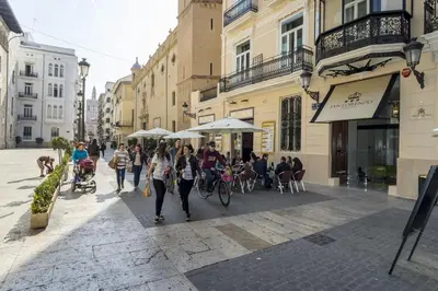 a group of people walking down a street with umbrellas at Hotel San Lorenzo Boutique Plaza in Valencia