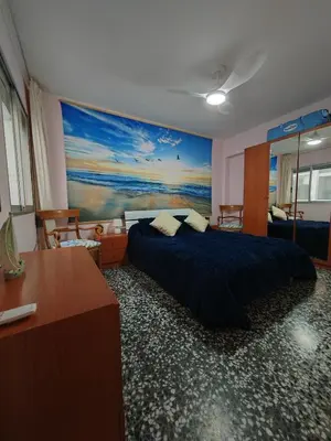 a bedroom with a bed and a painting on the wall at Vacances à la plage in Puerto de Sagunto