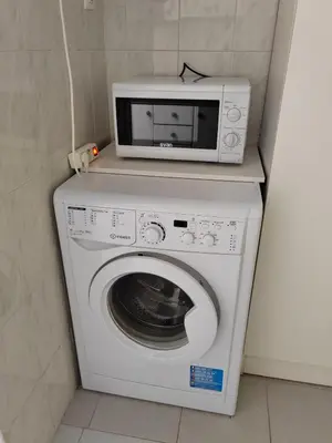 a microwave sitting on top of a washing machine at Vacances à la plage in Puerto de Sagunto