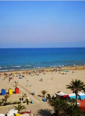 a beach with a lot of people and the ocean at Vacances à la plage in Puerto de Sagunto