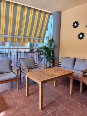 a wooden table and chairs on a balcony at 1Apartamento con piscina 2 linea de playa con acc valencia in Puzol