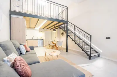 a living room with a couch and a staircase at Loft HomeValencia in Valencia
