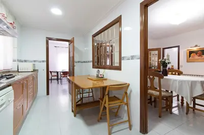 a kitchen and dining room with a table and chairs at Global Vacacional, Apartamento en Puerto de Sagunto in Puerto de Sagunto