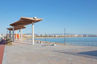 a bench under a pavilion next to a body of water at Global Vacacional, Apartamento en Puerto de Sagunto in Puerto de Sagunto