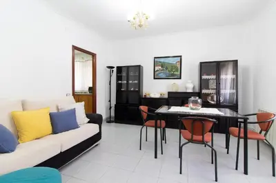 a living room with a couch and a table and chairs at Global Vacacional, Apartamento en Puerto de Sagunto in Puerto de Sagunto