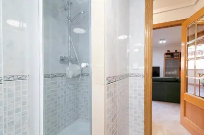 a bathroom with a shower with blue tiles at Global Vacacional, Apartamento muy cerca de la playa de Puerto de Sagunto in Puerto de Sagunto