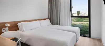 a white bed in a room with a window at B&B HOTEL Valencia Alcàsser in Alcácer