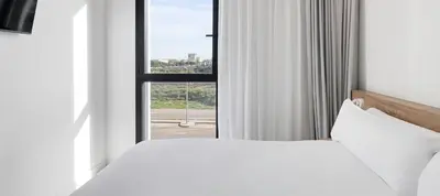 a bedroom with a white bed and a window at B&B HOTEL Valencia Alcàsser in Alcácer