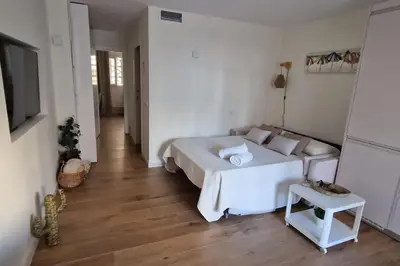 a bedroom with a white bed and a wooden floor at Brisa Marina Stay a unos pasos del mar in Valencia