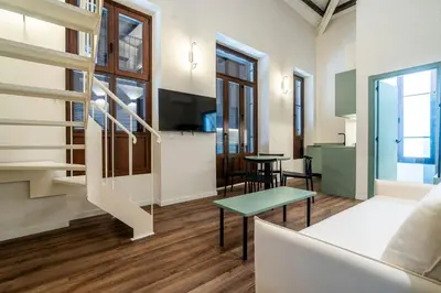 a living room with a staircase and a table at VLC HOST - Reina 168 in Valencia