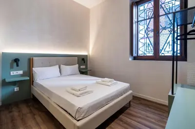 a bedroom with a bed with white sheets and a window at VLC HOST - Reina 168 in Valencia