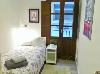a bedroom with a bed and a door with a window at Superb Central Market Apt in Valencia