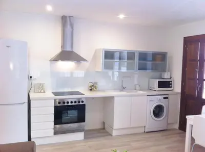 a white kitchen with a sink and a stove at Superb Central Market Apt in Valencia
