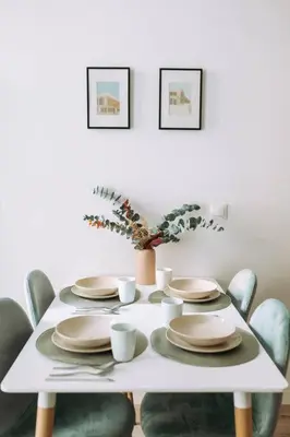 a white table with plates and cups and a vase at Parc Central Mint Apartment in Valencia