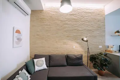 a living room with a couch and a brick wall at Parc Central Mint Apartment in Valencia