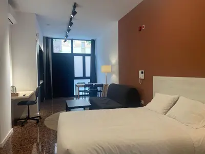 a bedroom with a bed and a desk and a chair at Apartahotel Espai Verd Benimaclet in Valencia