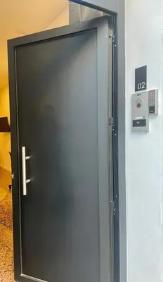 a black door with a silver handle on a wall at Apartahotel Espai Verd Benimaclet in Valencia