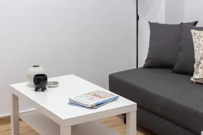 a white coffee table with a book on it next to a bed at VLC HOST- B&B Fray Pedro in Valencia