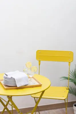 a yellow table and chair with plates and glasses at VLC HOST- B&B Fray Pedro in Valencia
