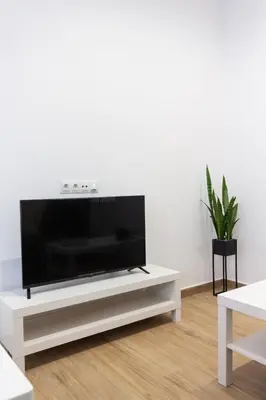 a flat screen tv sitting on top of a white entertainment center at VLC HOST- B&B Fray Pedro in Valencia