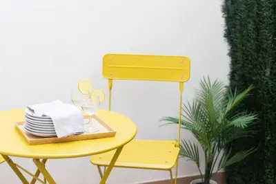 a yellow table with a plate of dishes and a chair at VLC HOST- B&B Fray Pedro in Valencia