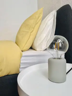 a table with a lamp and a couch with pillows at Habitación Cardenal 1 in Valencia
