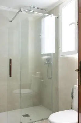 a bathroom with a glass shower with a toilet at Habitación Cardenal 1 in Valencia