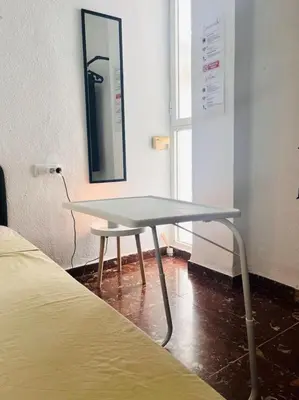 a table in a room with a bed and a mirror at Habitación Cardenal 1 in Valencia