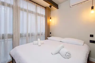 a bedroom with a white bed with towels on it at Apartamento acogedor frente a Mercat Central in Valencia