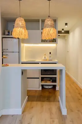 a kitchen with a white table and two lights at Apartamento acogedor frente a Mercat Central in Valencia