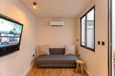 a living room with a couch and a flat screen tv at Apartamento acogedor frente a Mercat Central in Valencia