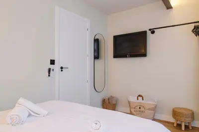 a bedroom with a bed with a tv on the wall at Apartamento acogedor frente a Mercat Central in Valencia