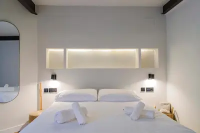 a bedroom with a white bed with two white pillows at Apartamento acogedor frente a Mercat Central in Valencia