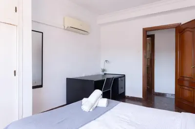 a white bedroom with a bed and a desk at Habitación Cardenal 2 in Valencia
