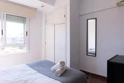 a white bedroom with a bed and a mirror at Habitación Cardenal 2 in Valencia