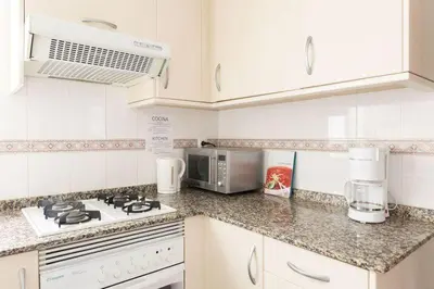 a white kitchen with a stove and a microwave at Habitación Cardenal 2 in Valencia