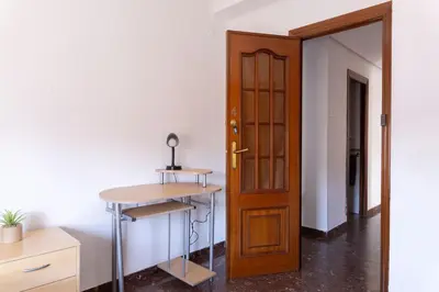 an empty room with a wooden door and a desk at Habitación Cardenal 4 in Valencia