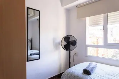 a white bedroom with a mirror and a fan at Habitación Cardenal 4 in Valencia