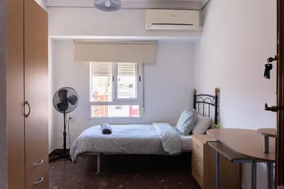 a bedroom with a bed and a desk and a window at Habitación Cardenal 4 in Valencia