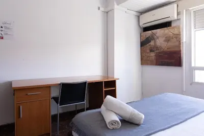 a bedroom with a desk and a bed with a chair at Habitación Cardenal 5 in Valencia