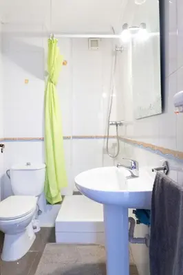 a white bathroom with a toilet and a sink at Habitación Cardenal 5 in Valencia