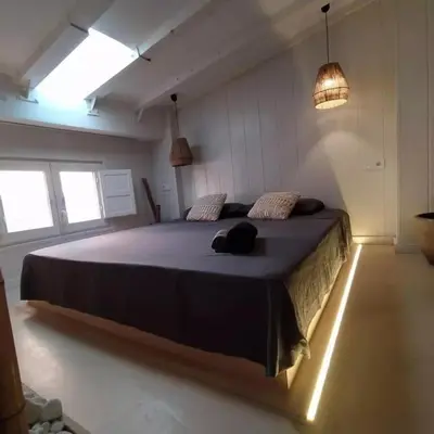 a bedroom with a large bed in a room with lights at Estudio Cama King in Valencia