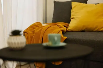 a coffee table in front of a couch with a yellow blanket at SANCHEZ Y LASERNA STAYS Moderno Apartamento en Valencia in Valencia