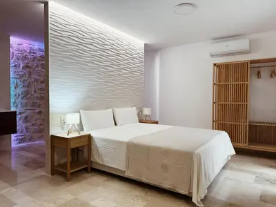 a bedroom with a large white bed and two tables at Bellver Home Apartamentos in Chella