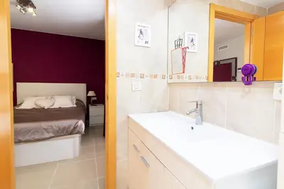 a bathroom with a sink and a bed at Global Vacacional, Moderno y práctico adosado en Puerto de Sagunto in Puerto de Sagunto