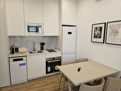 a kitchen with white cabinets and a table at HOB Miracle in Valencia