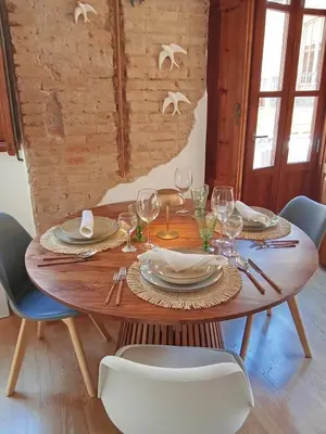 a wooden table with plates and wine glasses on it at Cozy flat in old town in Valencia