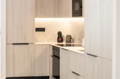a kitchen with white cabinets and a sink and a stove at Suite Deluxe Valencia - Ciudad de las Artes in Valencia